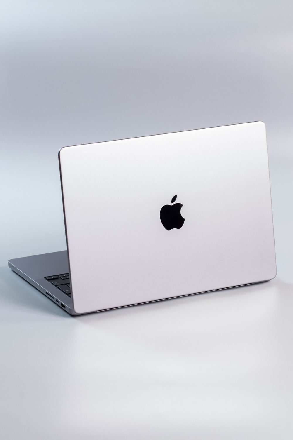 Silver MacBook laptop open on a studio background
